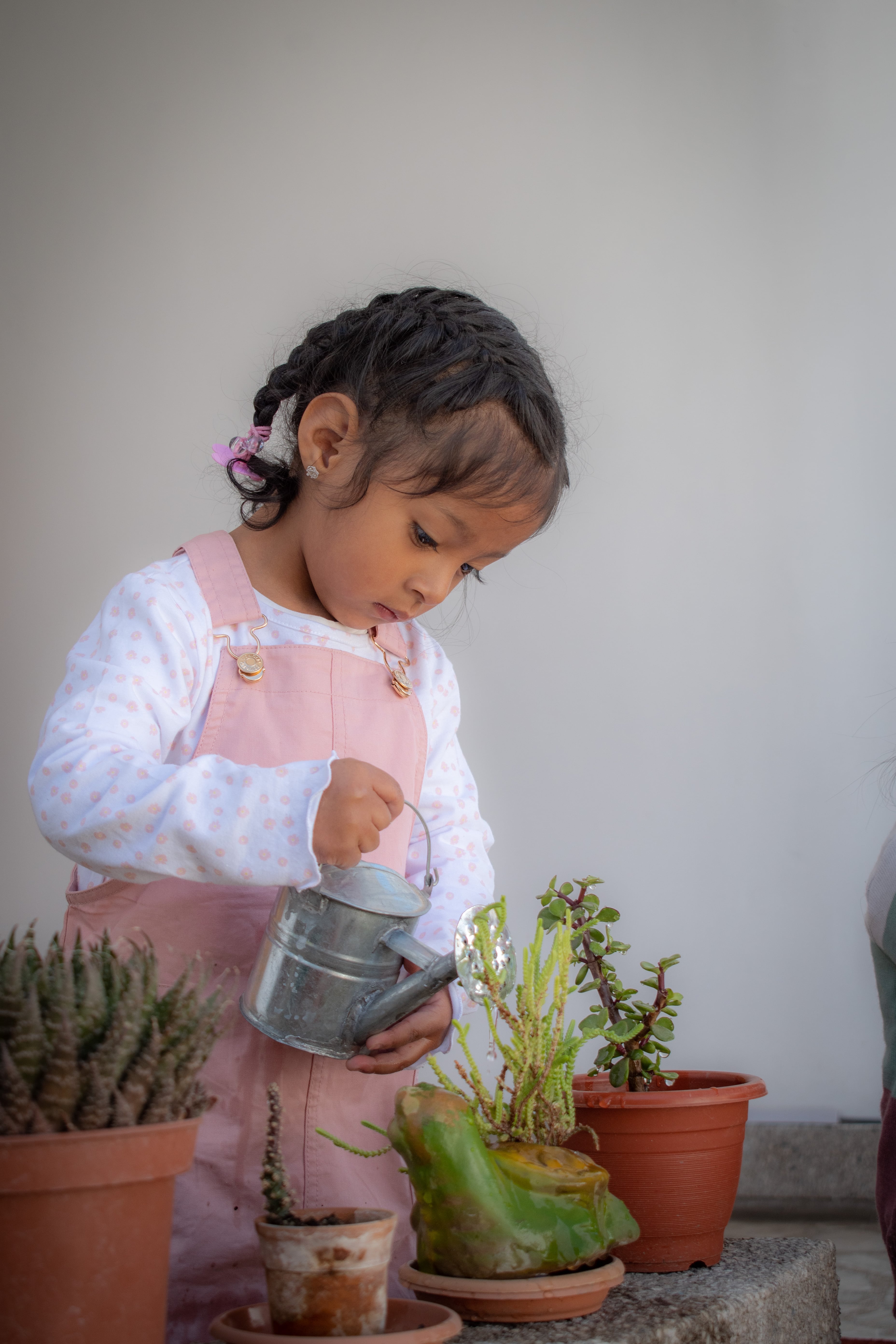 una niñita regando plantas