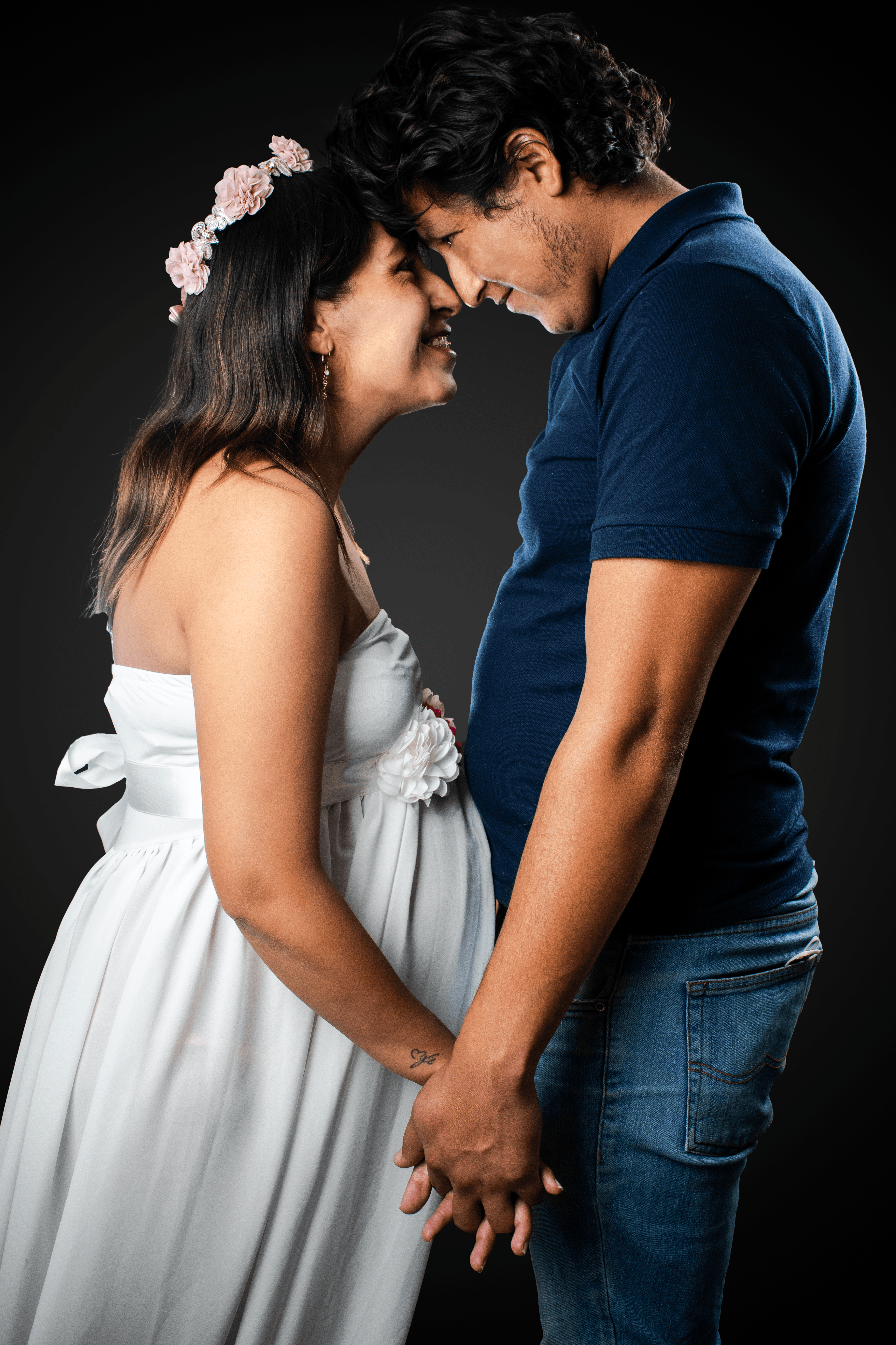 pareja de esposos mirandose, la enamorada en vestido blanco y embarazada